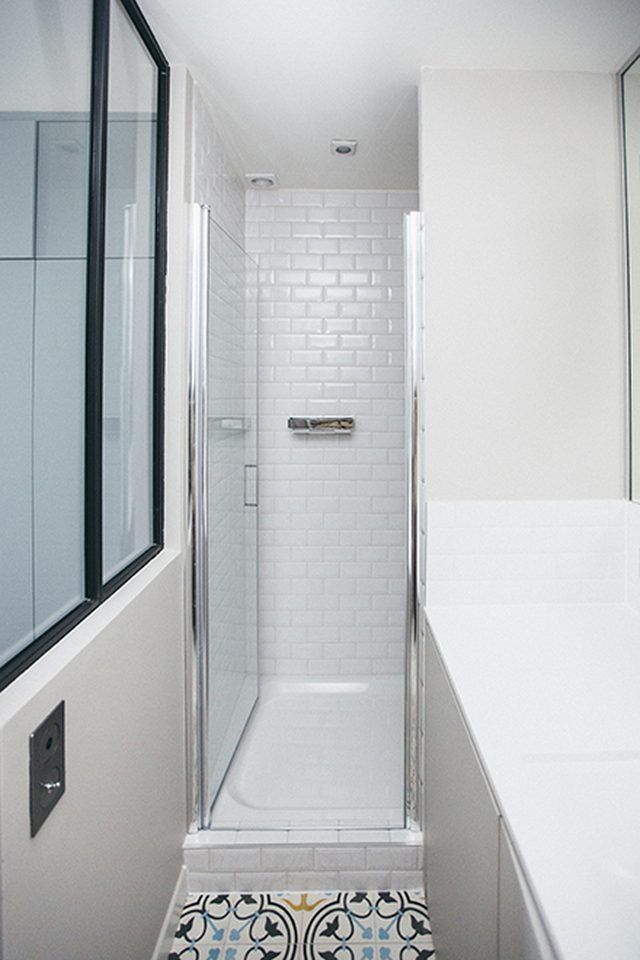 a bathroom with a shower, sink and mirror