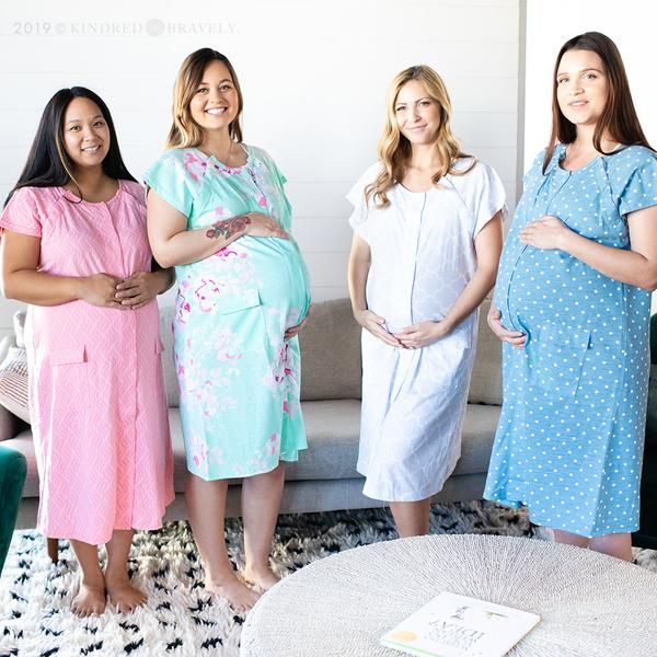 three pregnant women standing next to each other in front of a couch and coffee table