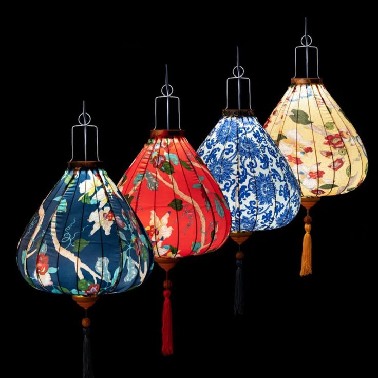 four different colored lamps hanging from wooden poles