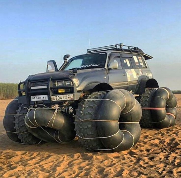 an off - road vehicle is parked in the sand with large tires attached to it