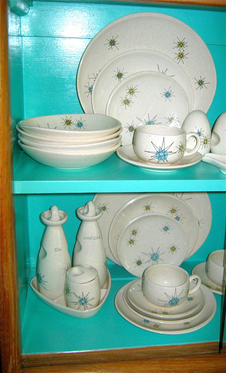 the china cabinet is full of dishes and cups, including one with stars on it