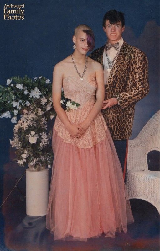 an old photo of two people dressed up in formal wear and standing next to each other