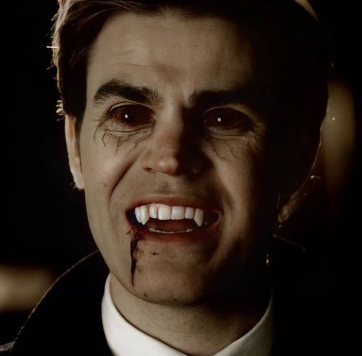 a close up of a person wearing a suit and tie with blood on his face