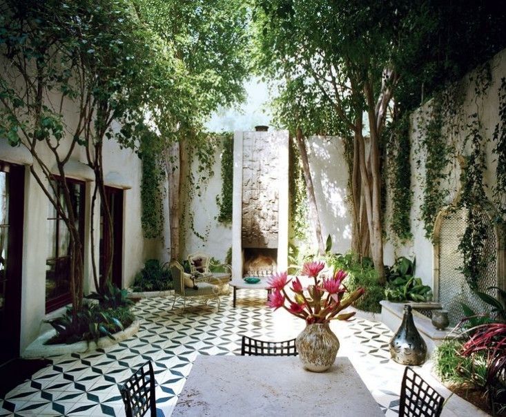 the inside of a house with an outdoor dining area and trees in the back ground