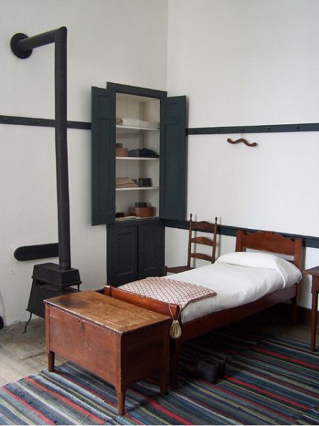 an old fashioned bed and desk in a room