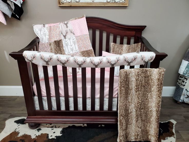 a baby crib with pink and brown bedding