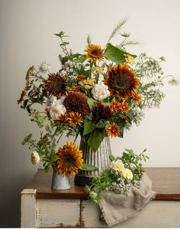 a vase filled with lots of flowers on top of a table