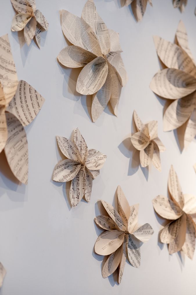 some paper flowers are hanging on the wall