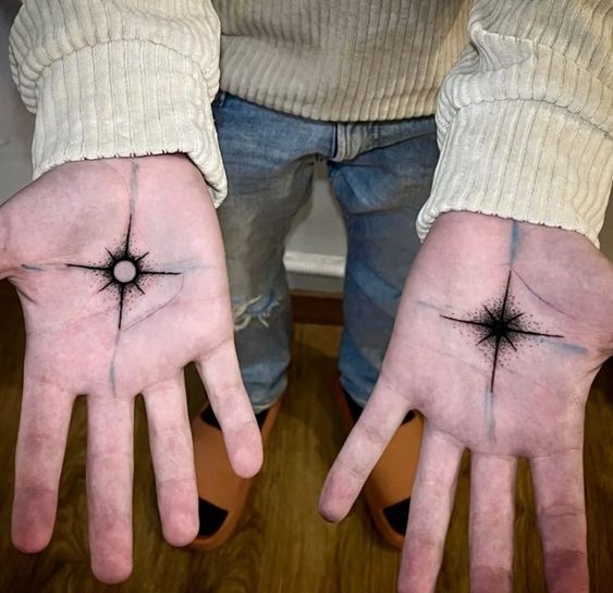 two hands with small black stars on them