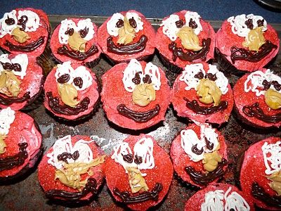 red cupcakes with white frosting and chocolate decorations on them are arranged in the shape of santa's faces