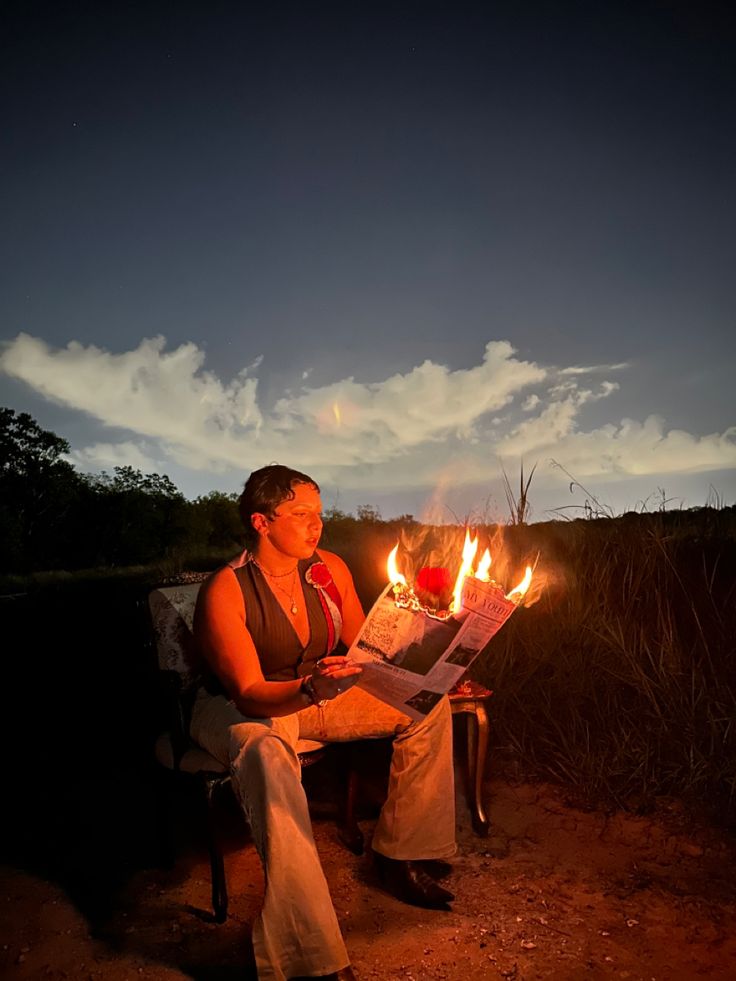 a woman sitting on a bench reading a newspaper with flames coming out of her mouth