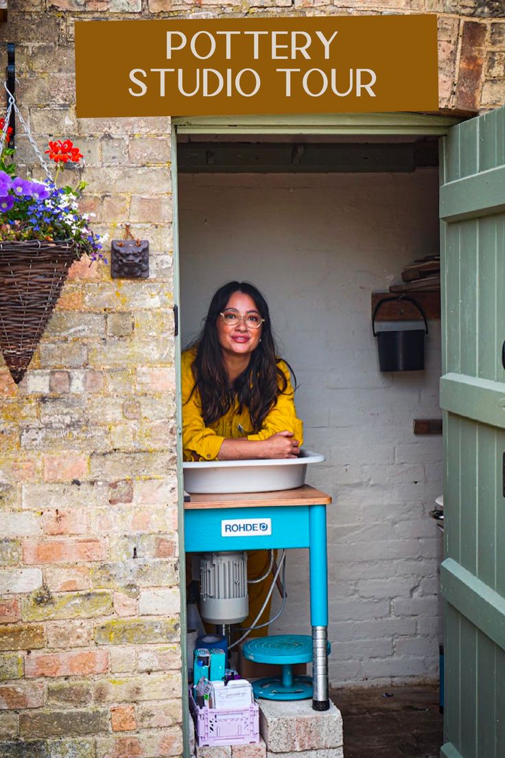 a woman sitting at a table in front of a brick building with the words pottery studio tour