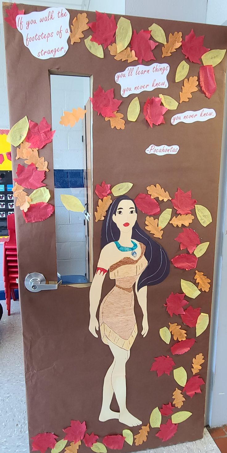 a door decorated with paper leaves and a woman's body in the center, surrounded by autumn leaves