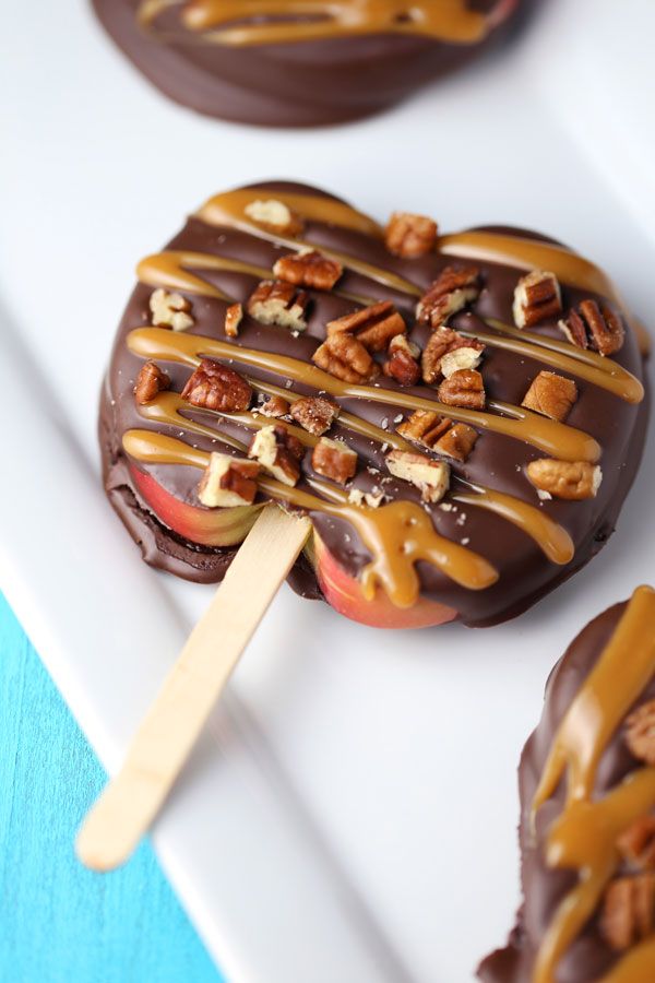 chocolate covered apple with caramel drizzled on top and pecans in the middle