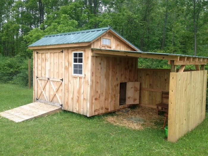 a small wooden shed sitting in the middle of a field