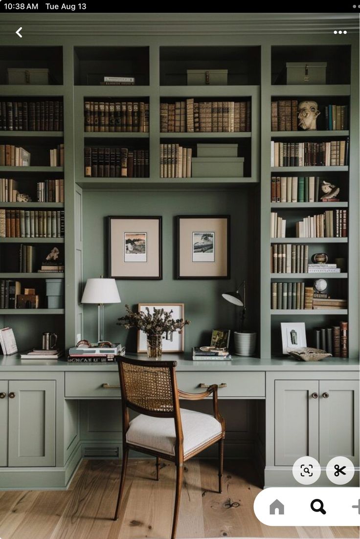 a home office with bookshelves, desk and chair in the middle of it