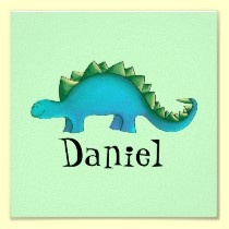 a blue and green dinosaur with the word daniel on it's chest, sitting in front of a white frame