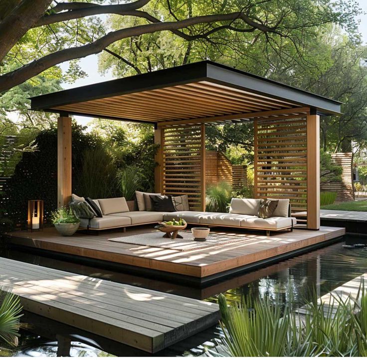 an outdoor living area with couches, tables and water feature in the middle of it