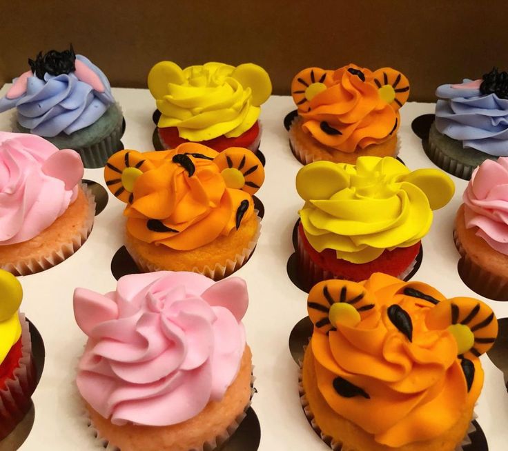 there are many cupcakes with frosting designs on the top one is tiger