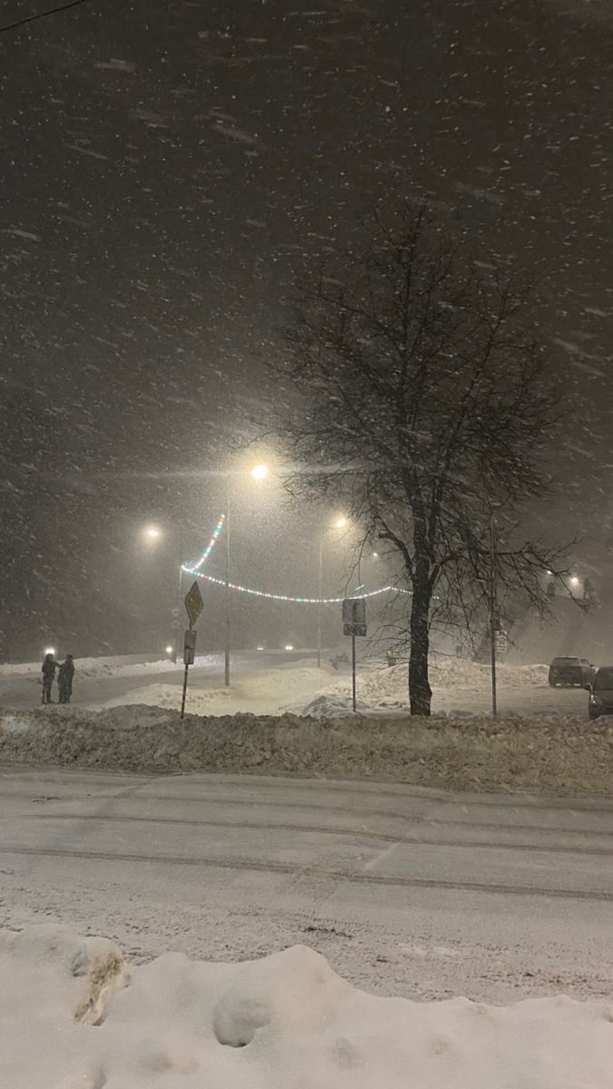 the street is covered in snow at night