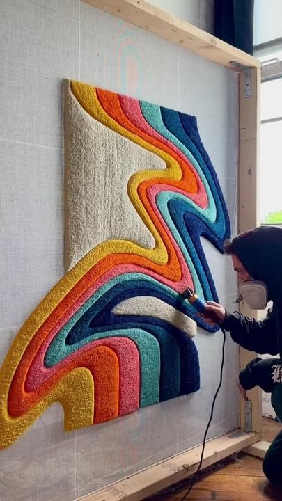 a woman is working on an art work in the process of being made with yarn