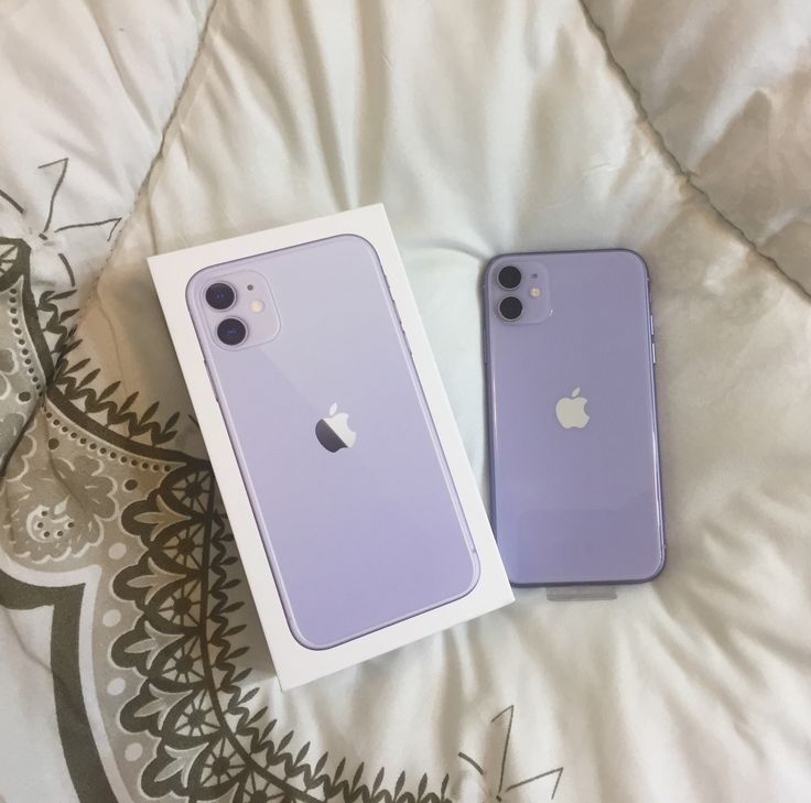 two purple iphones sitting next to each other on top of a white bed cover