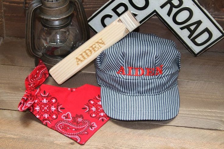 a baseball cap, bandana and hat clip sitting on top of a wooden table