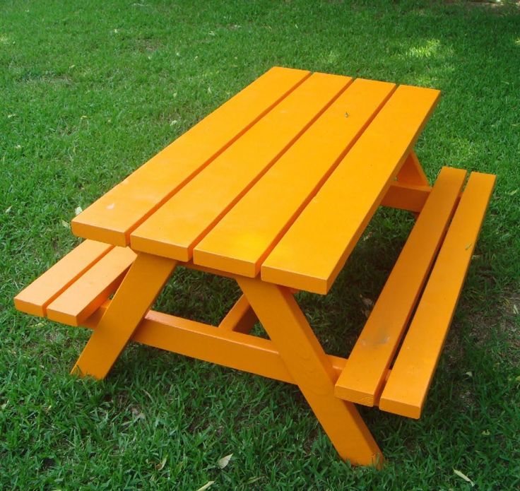 an orange picnic table sitting in the grass