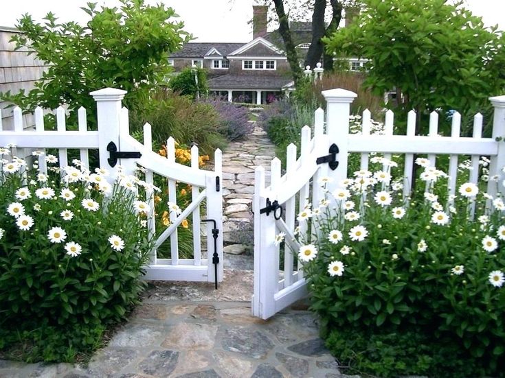 an open white gate leading into a garden