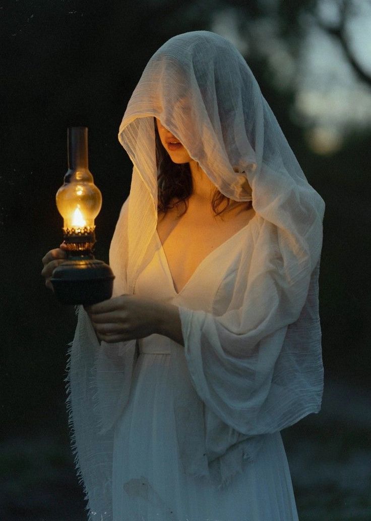 a woman dressed in white holding a light bulb