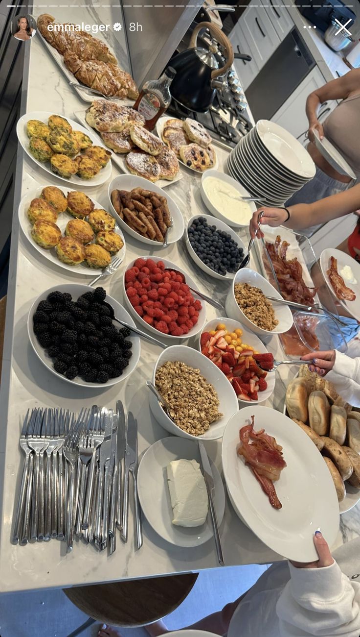 a buffet table filled with lots of different types of food on plates and silverware