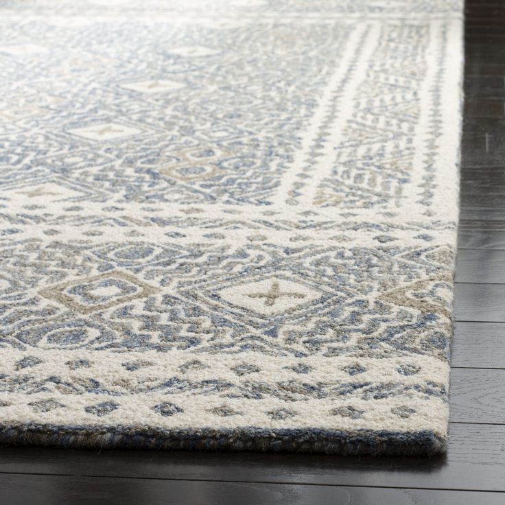 a blue and white rug on a wooden floor with dark wood floors in the background