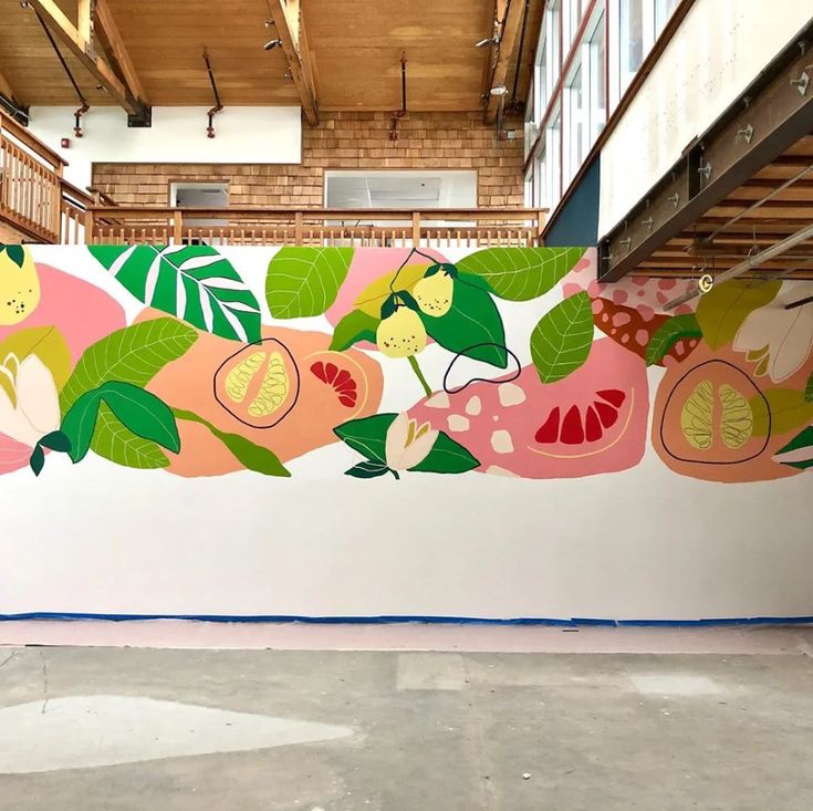 a large mural on the side of a building with fruit and leaves painted on it