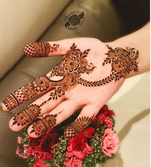 a woman's hand with hennap on it and flowers in the background