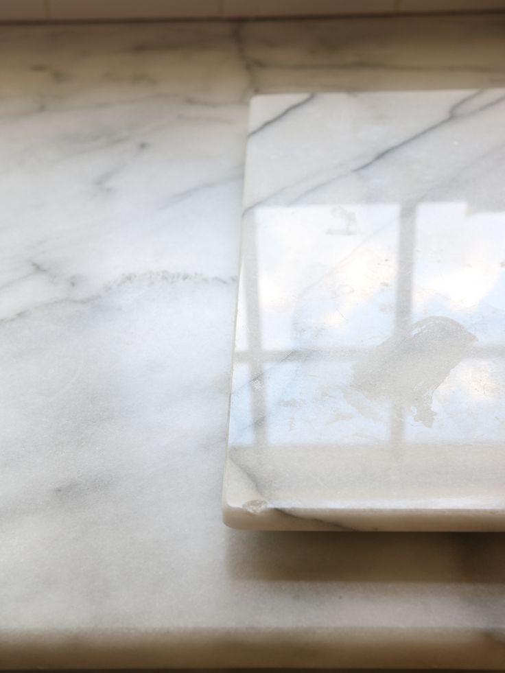 a marble counter top with a white square shaped object on it's side,