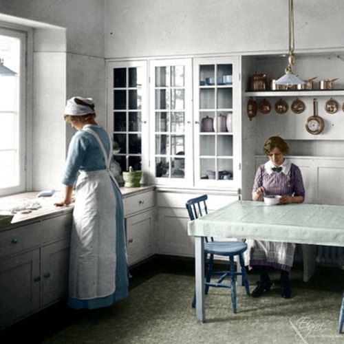 two women sitting at a table in a kitchen