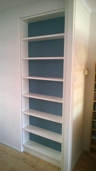 an empty book shelf in the corner of a room