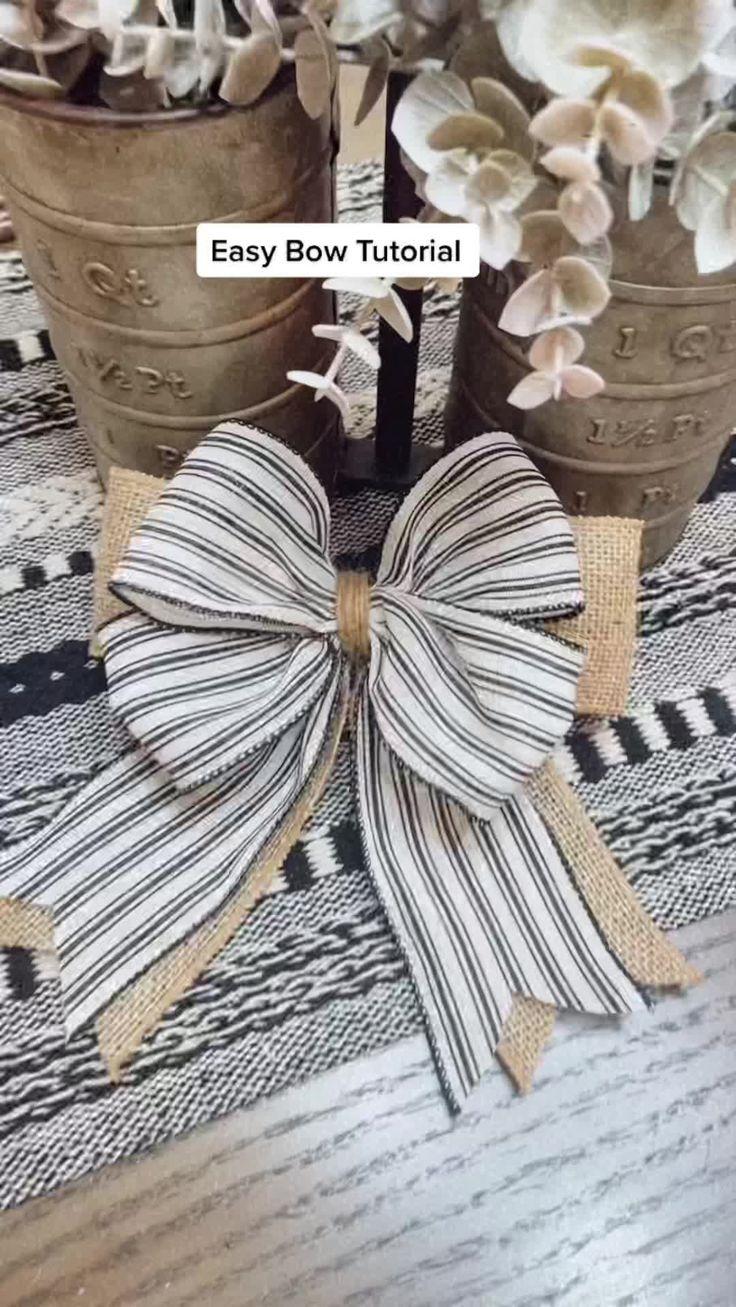 two flower pots with bows on them sitting on a table