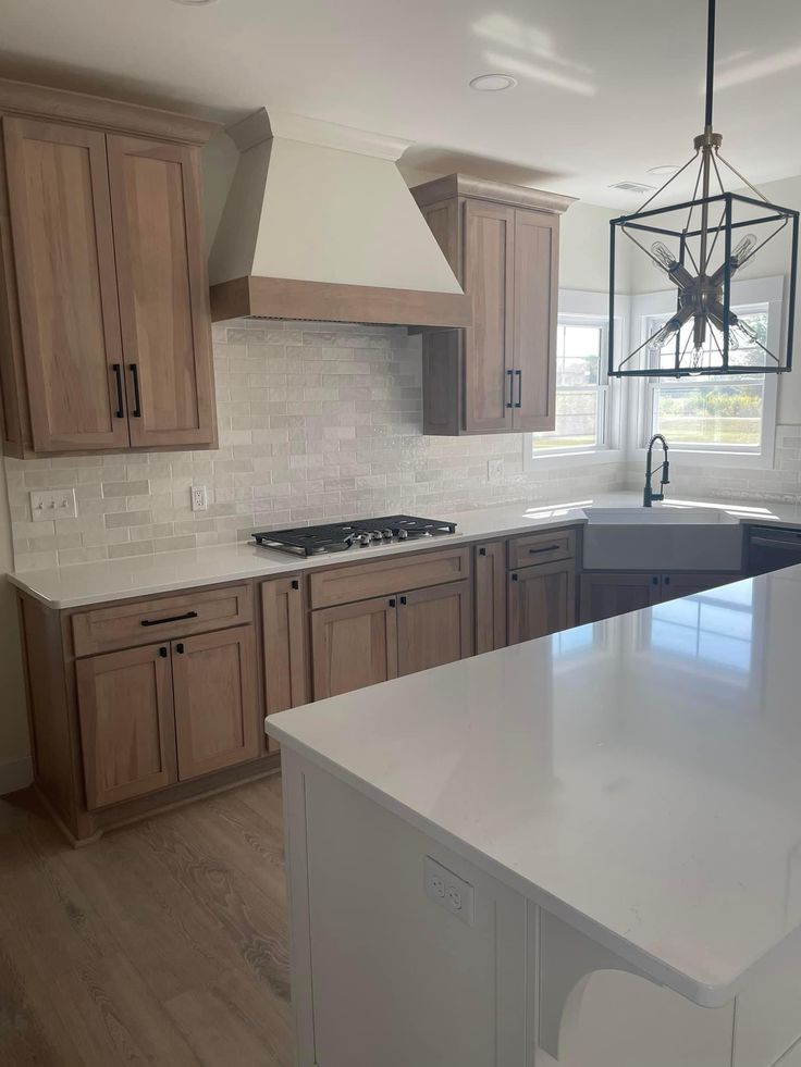 a kitchen with white counter tops and wooden cabinets