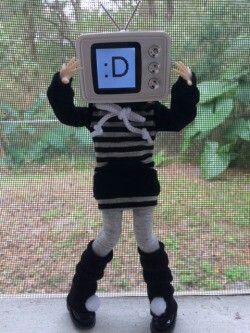 a stuffed animal is holding up a computer monitor with the letter d on it's face