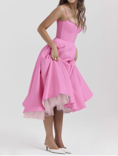 a woman in a pink dress posing for the camera with her hands on her hips