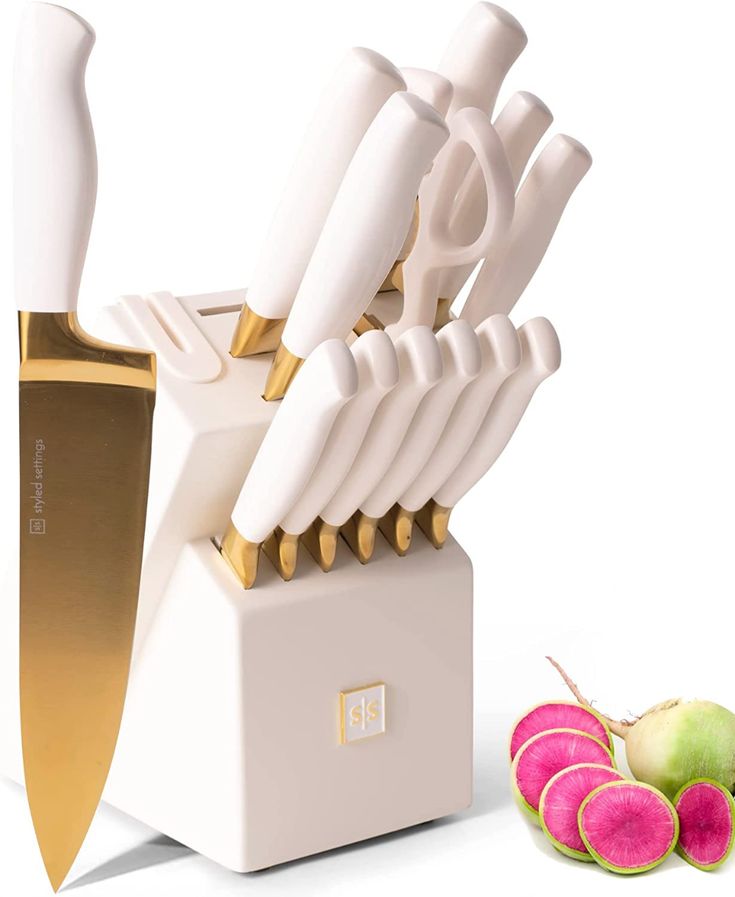 a white and gold knife block next to some fruit