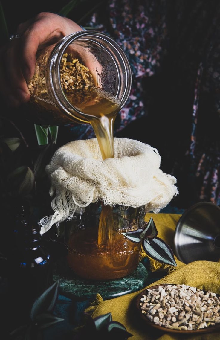 a person pouring honey into a jar filled with oatmeal and other ingredients