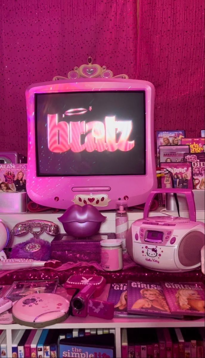 a pink desktop computer sitting on top of a table next to other toys and games