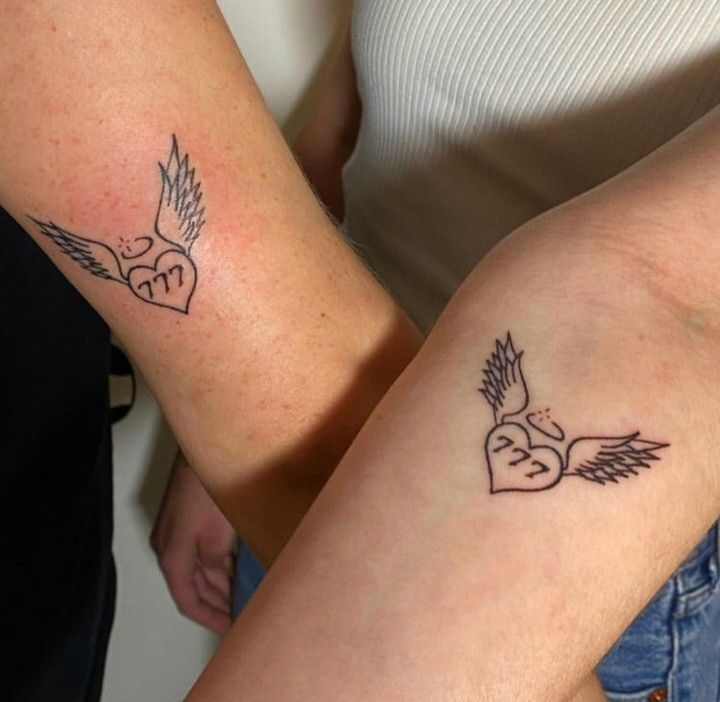 two people with matching tattoos on their arms