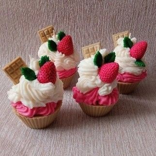 four cupcakes with strawberries and whipped cream on top are arranged in the shape of waffle cones