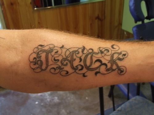 a man's arm with the word tattoo on it