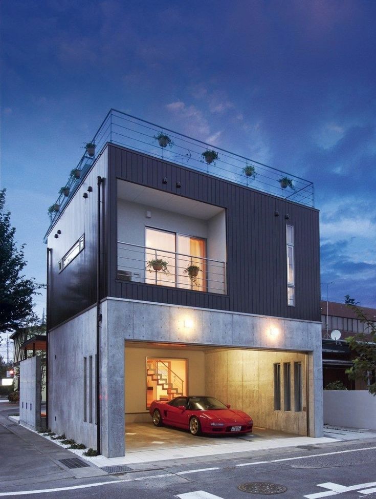 a car is parked in front of a two story house with an attached balcony and balconies on the second floor