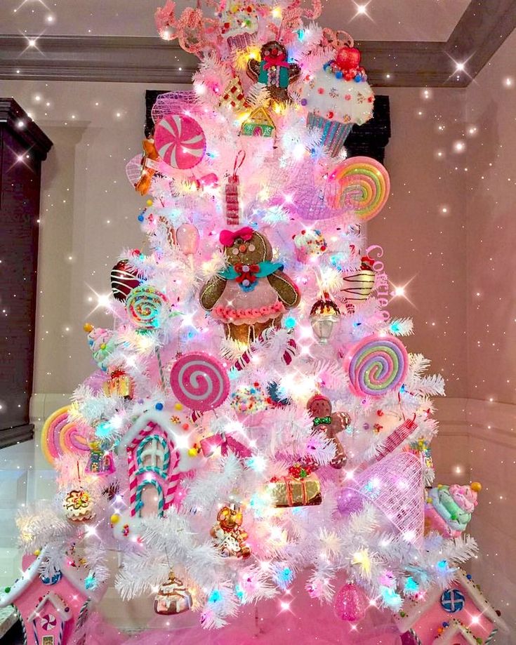 a pink christmas tree decorated with candy and lollipops