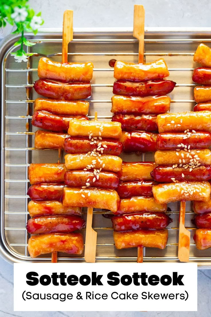 hotdogs on skewers covered in ketchup and sesame seeds are ready to be cooked